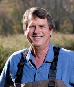 Darold Batzer a blue shirt poses outside.