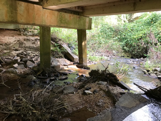 A river and the underside of a bridge are visible.