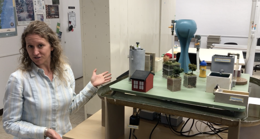 person stands in front of miniature town