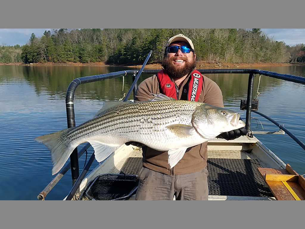 A man holds a large bass